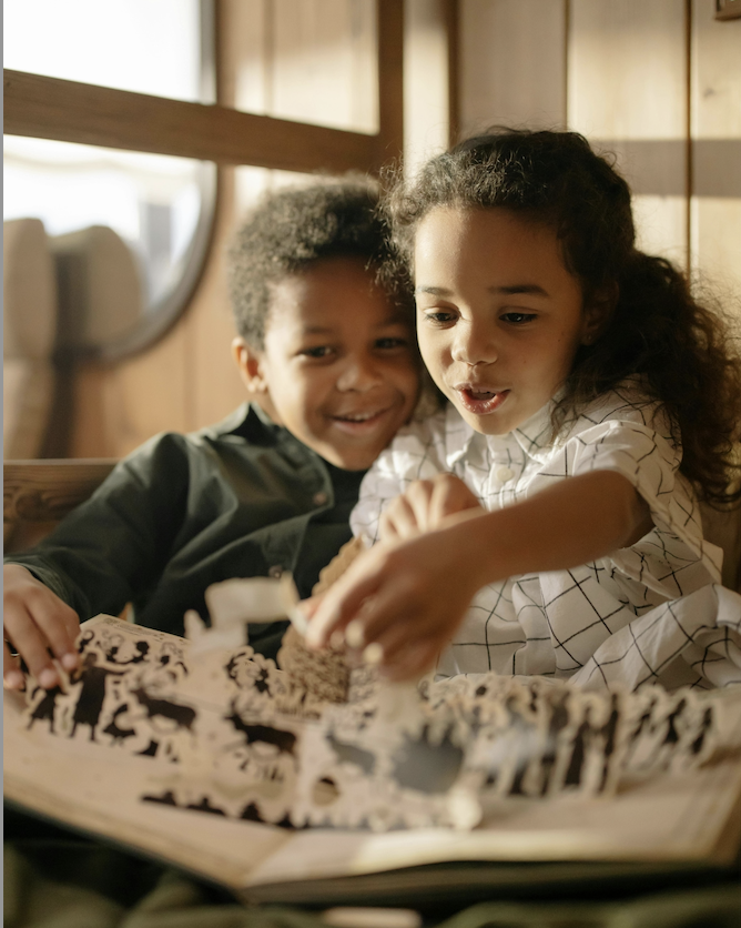 Two children sitting on a couch imagining and sharing ideas together